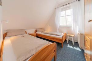 um pequeno quarto com 2 camas e uma janela em Ferienwohnung Lüttje Huck - Seeblick 3 em Aurich