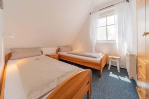 a small bedroom with two beds and a window at Ferienwohnung Lüttje Huck - Seeblick 3 in Aurich