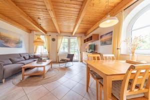 a living room with a table and a couch at Ferienwohnung Lüttje Huck - Seeblick 3 in Aurich