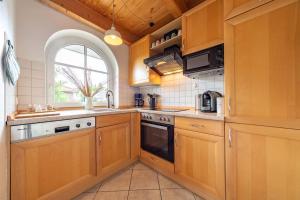 uma cozinha com armários de madeira e uma janela em Ferienwohnung Lüttje Huck - Seeblick 3 em Aurich