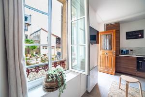 Habitación con balcón con ventanas y cocina. en Lovely Apartment Palace of Versailles, en Versalles