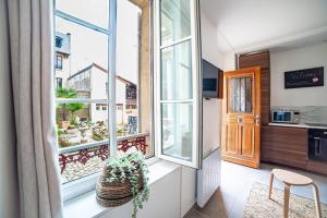 a room with a balcony with windows and a kitchen at Lovely Apartment Palace of Versailles in Versailles