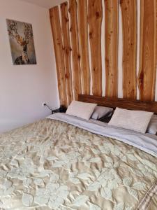 Ce lit se trouve dans une chambre dotée d'un mur en bois. dans l'établissement APARTMA JEREBIKA ŠT. 20, à Hočko Pohorje