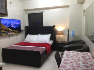 een kleine slaapkamer met een bed en een bank bij THE VISTA BRENT HILL BAGUIO in Baguio