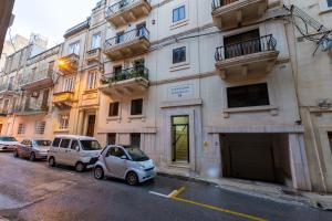 two cars parked in front of a building at Xmajjar in Sliema
