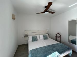 Un dormitorio con una cama con ventilador de techo. en Apartamento Jameos-Los Molinos Costa Teguise, Lanzarote, en Costa Teguise 33 fotos más