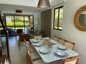 嘎林海斯港的住宿－Muro alto Bangalô beach class ecolife，一间配备有白色桌椅的用餐室