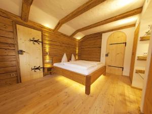 1 dormitorio con 1 cama en una habitación con paredes de madera en Wimmerhof, en Inzell