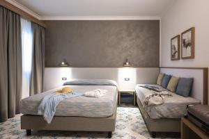 a hotel room with two beds with towels on them at Mia Resort Paestum in Paestum