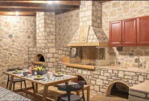 a kitchen with a table and a stone oven at Villa Kermes Heated Pool in Kournás