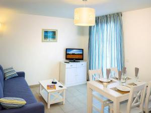 a living room with a blue couch and a table at Terres de France - Résidence de la Cabre d'Or in Cabriès