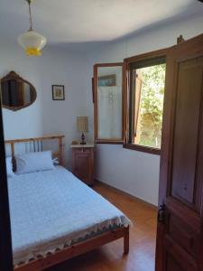 um quarto com uma cama e uma janela em Athena's Guest House em Stagiates