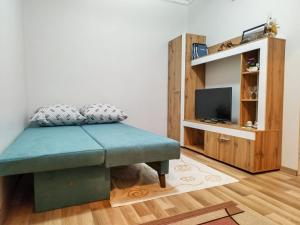 a living room with a bench and a tv at Villa Bella - A Rila Monastery Adventure in Kocherinovo