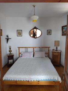 een slaapkamer met een bed en een spiegel aan de muur bij Athena's Guest House in Stagiates
