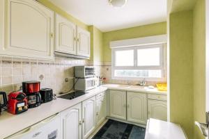 a kitchen with white cabinets and a window at Marvellous Studio Paris 14 in Gentilly