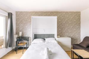 1 dormitorio con 1 cama blanca grande y 1 sofá en Marvellous Studio Paris 14 en Gentilly