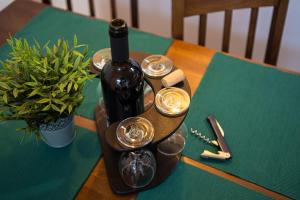 a bottle of wine and glasses on a table at Henriett’s cosy place in Satu Mare