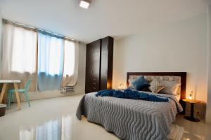 1 dormitorio con 1 cama con edredón azul en Pepe's House Guayaquil I MicroHostel Self Check-In, en Guayaquil