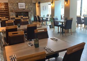 a restaurant with wooden tables and chairs and a fireplace at The Roost on Rock Road in Barry