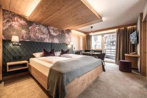 una camera da letto con un letto grande e una scrivania di 4*S Galtenberg Resort ad Alpbach