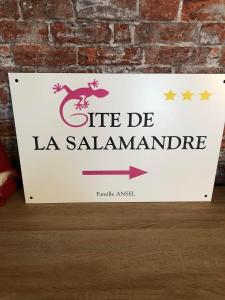 un letrero para un restaurante la salamanca en una pared de ladrillo en Gîte de la Salamandre - 4 à 8 personnes, en Lapoutroie