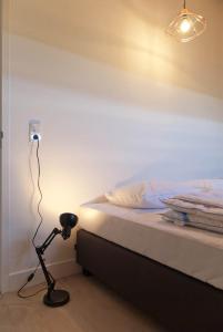 een kamer met een bed en een lamp ernaast bij Vakantieverblijf de Trommel in Domburg