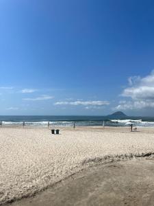 a beach with a group of people and the ocean at Delba Costa Smeralda - Barra do Una in Barra do Una