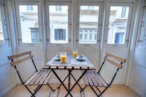 - une table avec deux chaises et deux verres de jus d'orange dans l'établissement Beautifully finished and large apartment steps away from rocky beach DDIF1-1, à Sliema