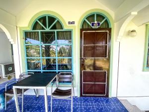 un tavolo e sedie di fronte a una porta di Karon house 15A a Karon Beach