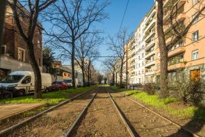 an empty street with train tracks in a city at Maciachini Apartments R&R in Milan