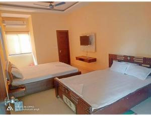 um quarto com 2 camas e uma janela em Hotel Diamond Vihar, Rajgir em Rajgir