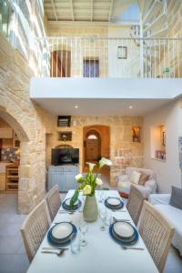 een eetkamer met een witte tafel en stoelen bij Casa Bartolo A Hidden Gem - Spacious Village Home EBAR1-1 in Lija