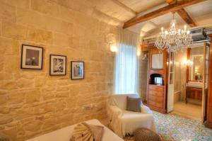 ein Wohnzimmer mit einer Steinmauer in der Unterkunft Casa Bartolo A Hidden Gem - Spacious Village Home EBAR1-1 in Lija