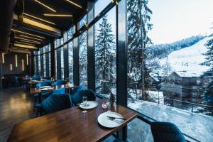 un restaurante con mesas, sillas y ventanas grandes en BLUE mountain en Bukovel
