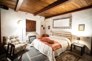 1 dormitorio con 1 cama y 1 silla en Villa Ghiringhelli, en Azzate