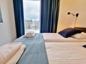 - 2 lits dans une chambre d'hôtel avec fenêtre dans l'établissement Apartament Bliżej Morza w Gąskach - 365PAM, à Gąski
