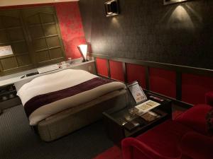 um quarto de hotel com uma cama e um sofá em ホテル フェリエ hotel for adults em Hachioji