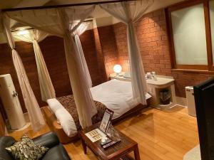um quarto com uma cama de dossel e um lavatório em ホテル フェリエ hotel for adults em Hachioji