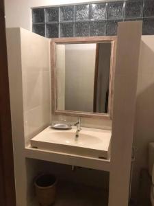 a bathroom with a sink and a mirror at Arsa Wayan Guest House in Klungkung