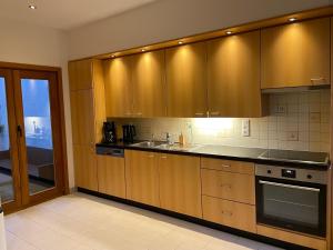 a kitchen with wooden cabinets and a sink at Maison Nausikaa in Ostend