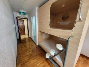 シンガポールにあるWink at Upper Cross Streetの廊下に二段ベッドが備わる小さな客室です。