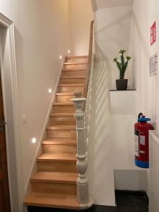 a stairwell with wooden stairs and a fire extinguisher at Maison Nausikaa in Ostend