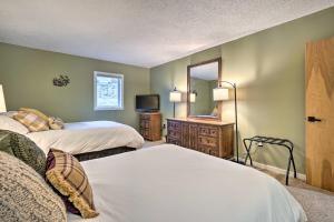 een hotelkamer met 2 bedden en een spiegel bij Cozy Ski-InandSki-Out Condo on Magic Mountain in Londonderry