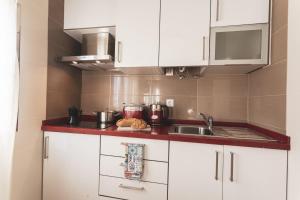 een keuken met witte kasten en een wastafel bij Best Houses 04 - Loft in the Heart of Peniche in Peniche