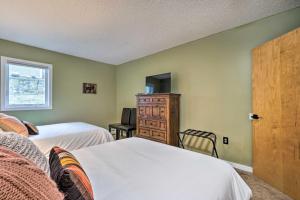 a bedroom with two beds and a cabinet and a window at Cozy Ski-In/Ski-Out Condo on Magic Mountain in Londonderry