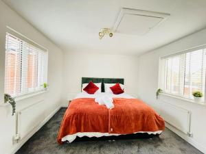 a white bedroom with a large bed with red pillows at Plantsbrook Place - Luxury 4 bed House + Parking in Birmingham