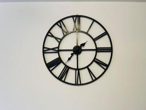 a black and white clock on a white wall at Plantsbrook Place - Luxury 4 bed House + Parking in Birmingham