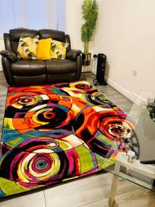 Habitación con sofá y manta colorida. en Plantsbrook Place - Luxury 4 bed House + Parking, en Birmingham
