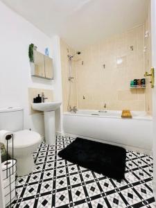 a bathroom with a tub and a toilet and a sink at Plantsbrook Place - Luxury 4 bed House + Parking in Birmingham