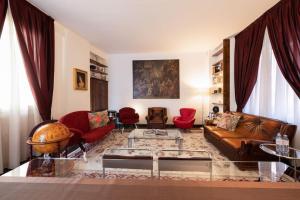 ein Wohnzimmer mit einem Ledersofa und roten Stühlen in der Unterkunft Spiga Duplex Suites by Montenapoleone Living in Mailand
